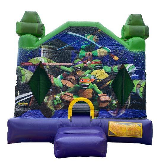 A bouncy house with a picture of teenage mutant ninja turtles on it.