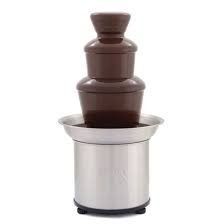 A chocolate fountain is sitting on top of a stainless steel container on a white background.