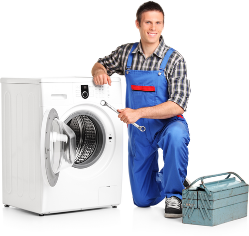 A man is kneeling next to a washing machine holding a wrench.