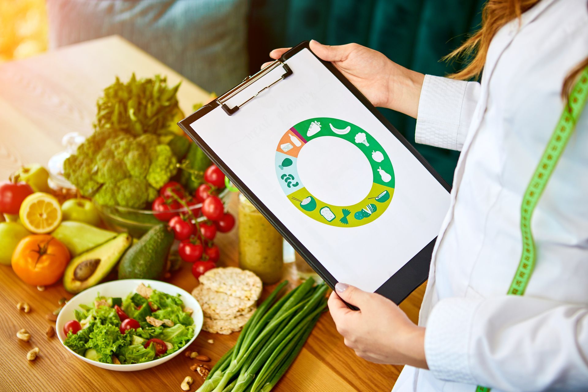 A woman is holding a clipboard with a circle on it in front of a table full of fruits and vegetables.