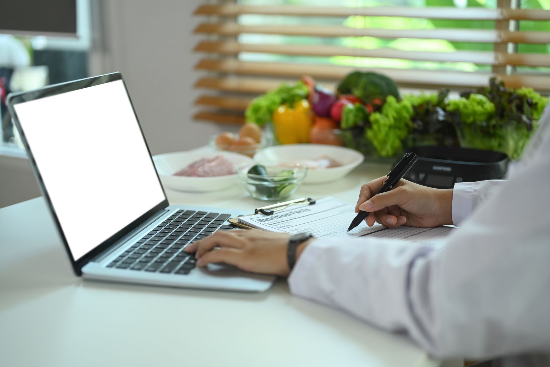 A person is sitting at a table using a laptop computer.