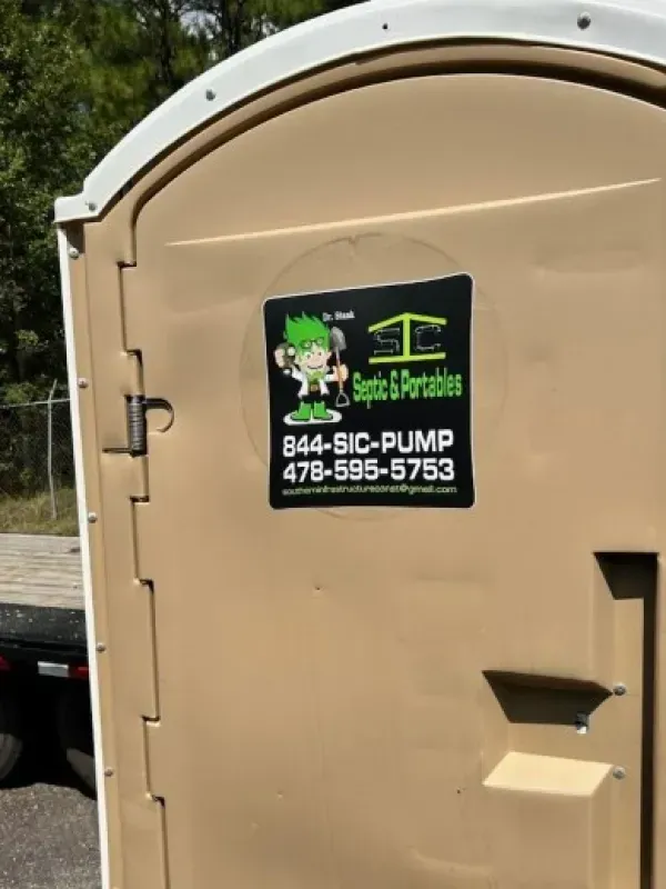 A portable toilet with a sticker on it that says septic & portables
