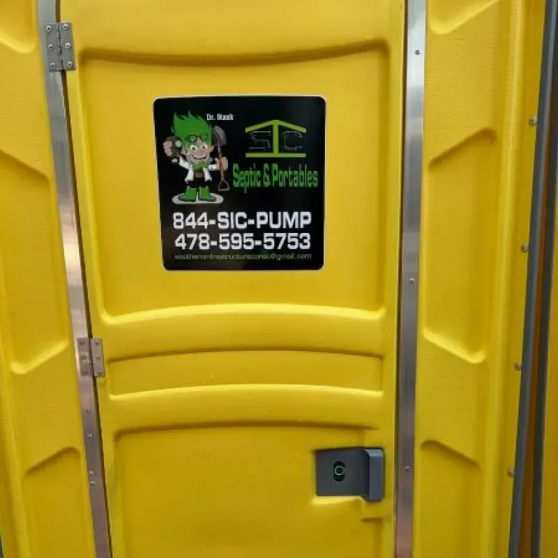 A yellow portable toilet with a sticker on it that says septic & portables