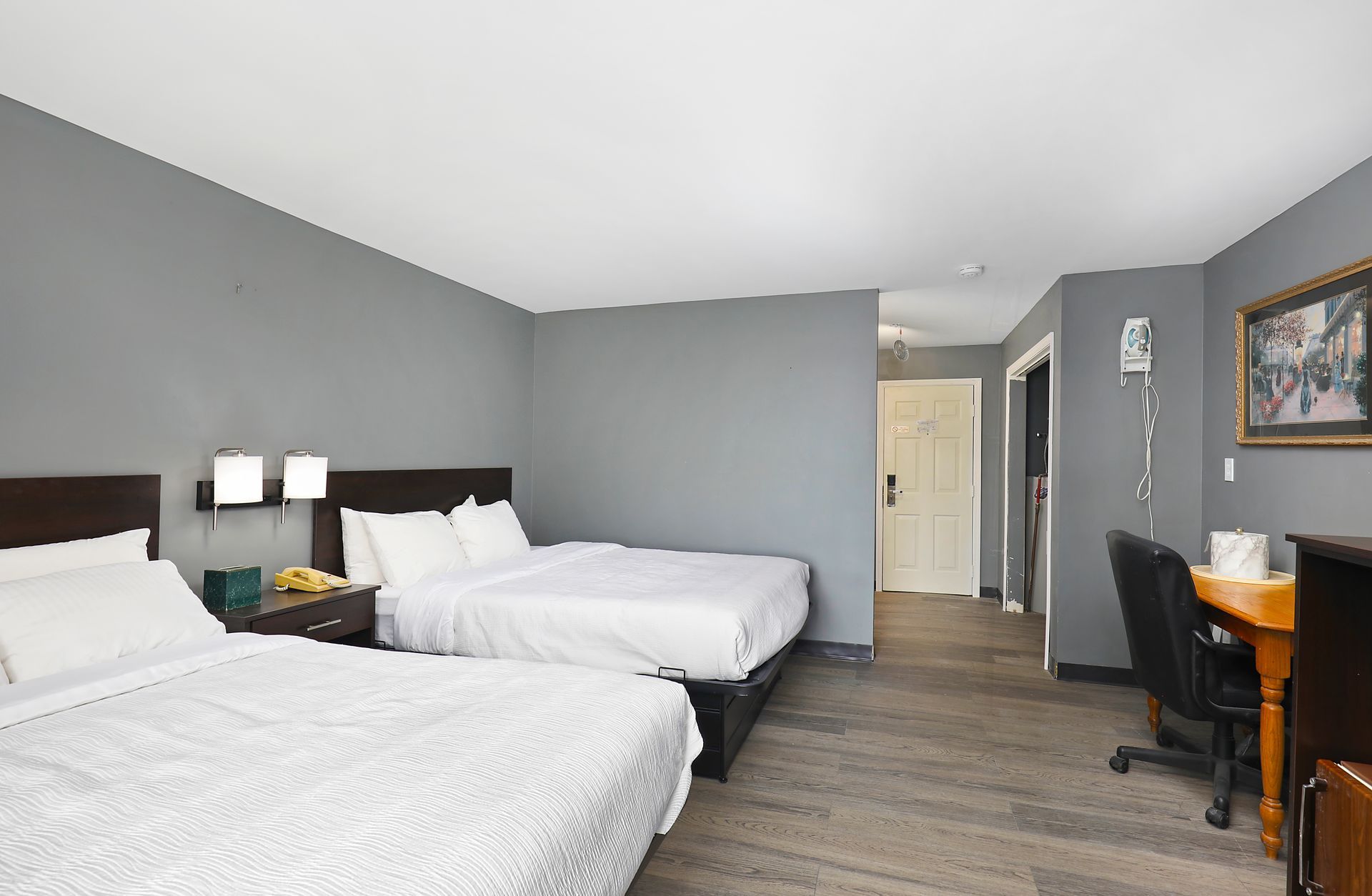 A hotel room with two beds and a desk.