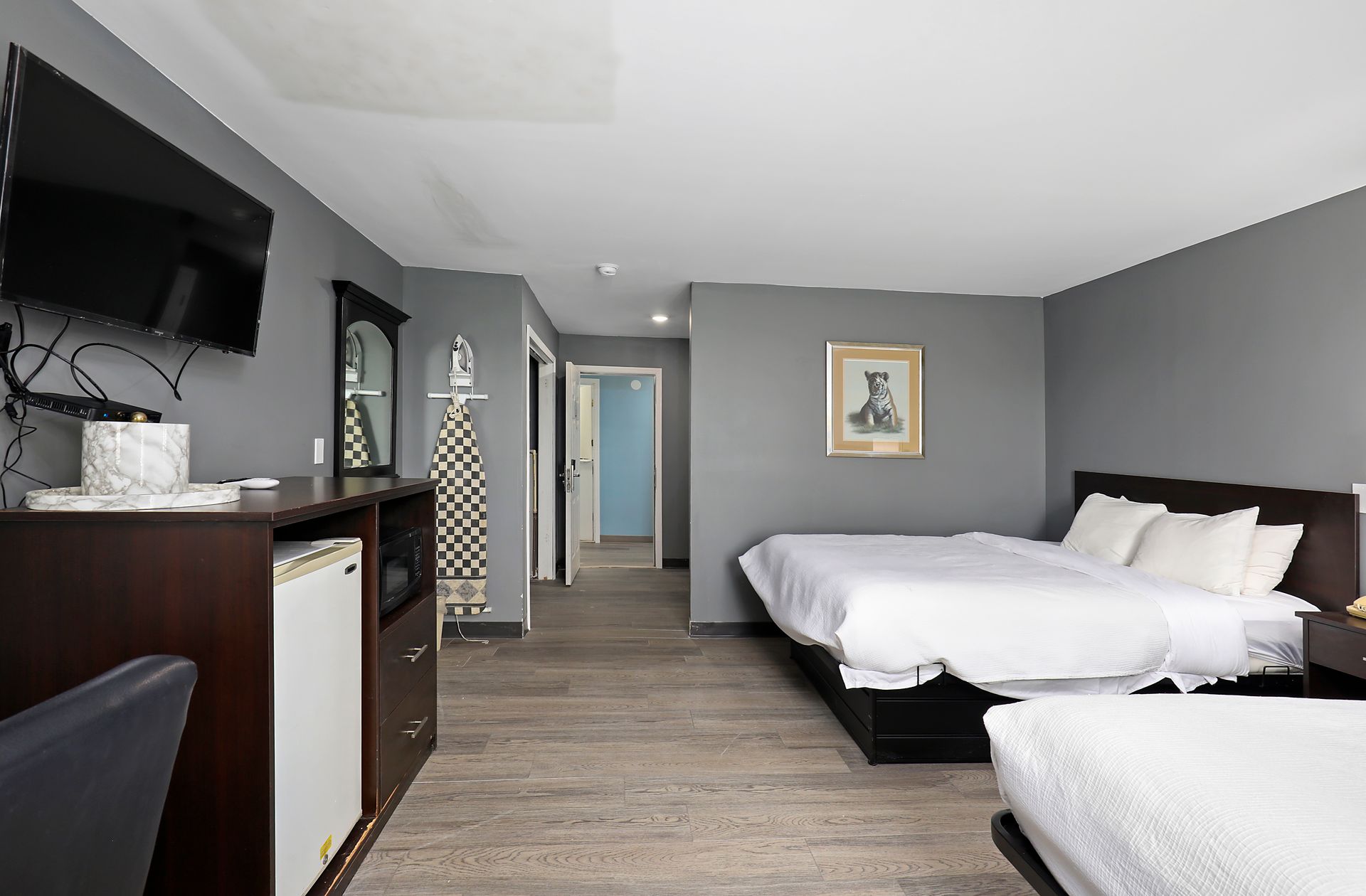 A hotel room with three beds and a flat screen tv.