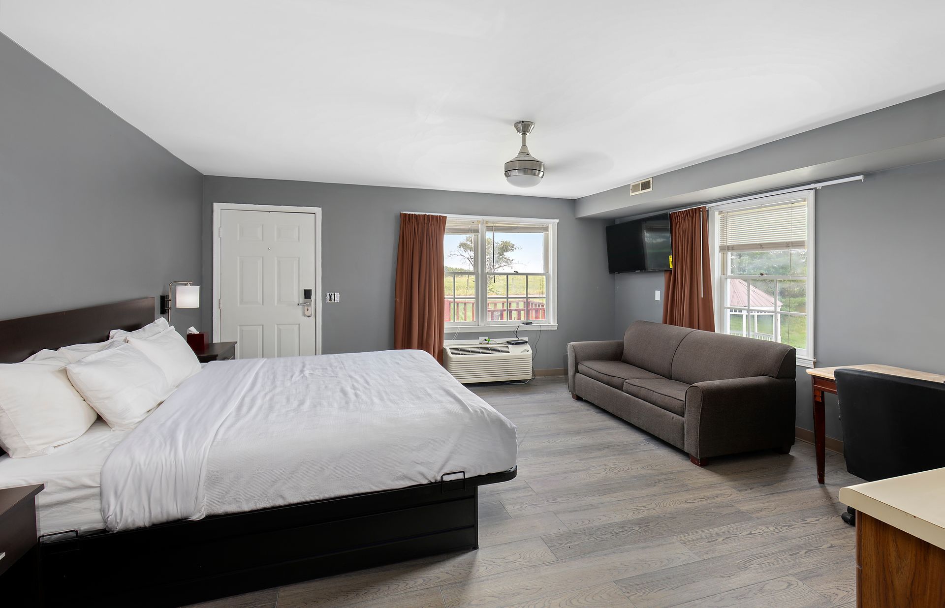 A hotel room with a king size bed and a couch.