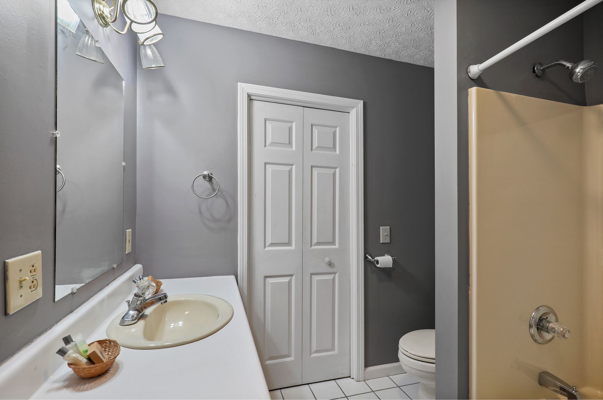 A bathroom with a sink , toilet , shower and mirror