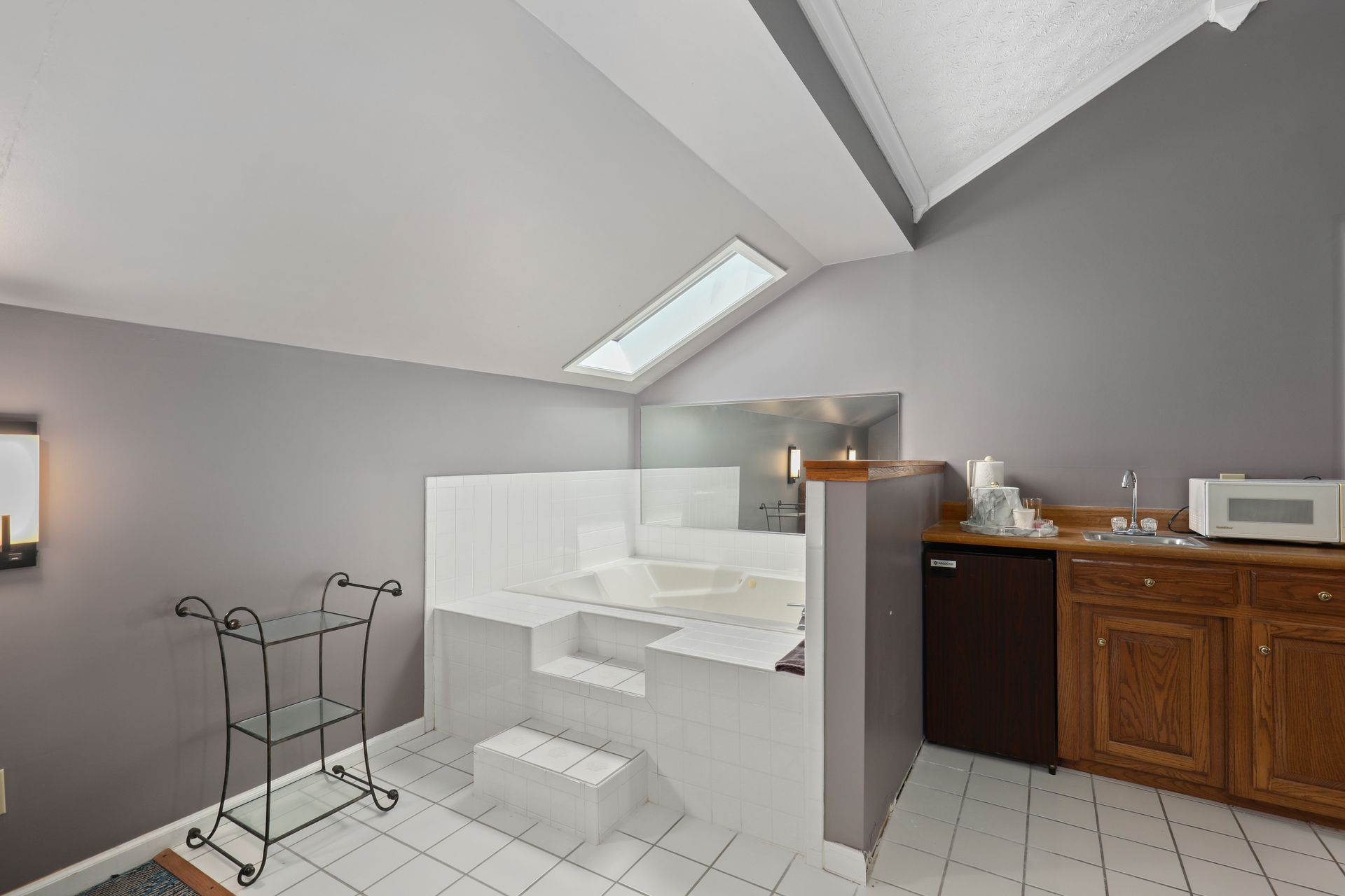 A kitchen with a bathtub and a microwave