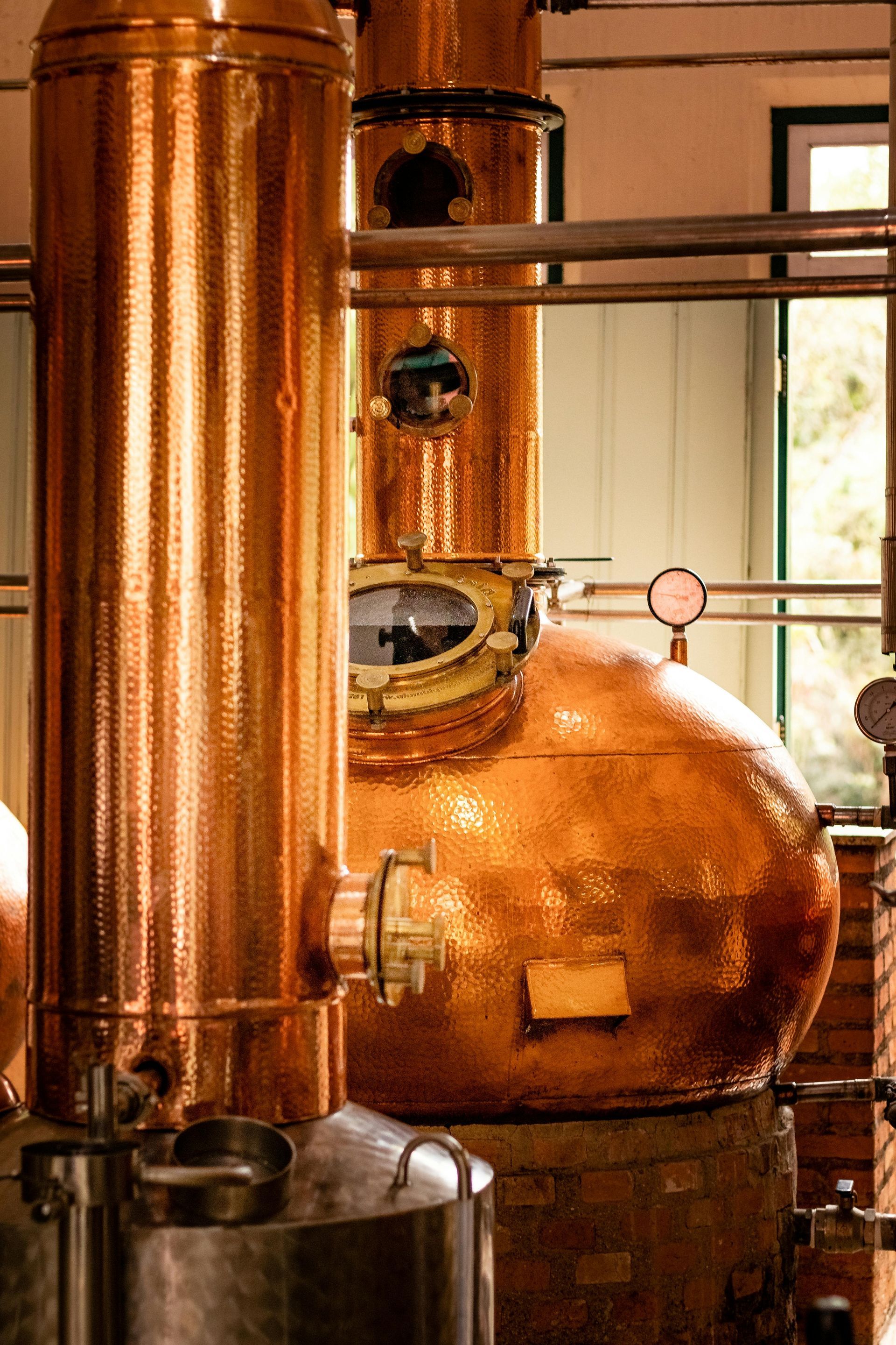 A copper distillery is being used to make alcohol in a factory.