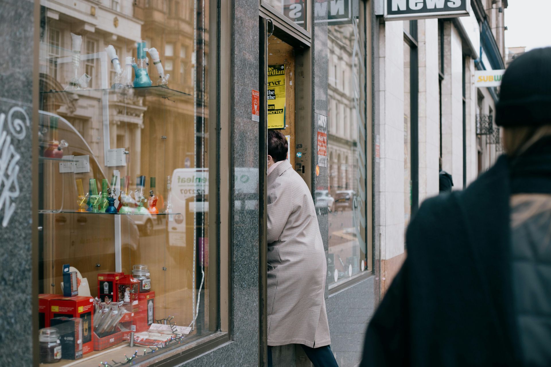 A woman is standing in front of a store window.