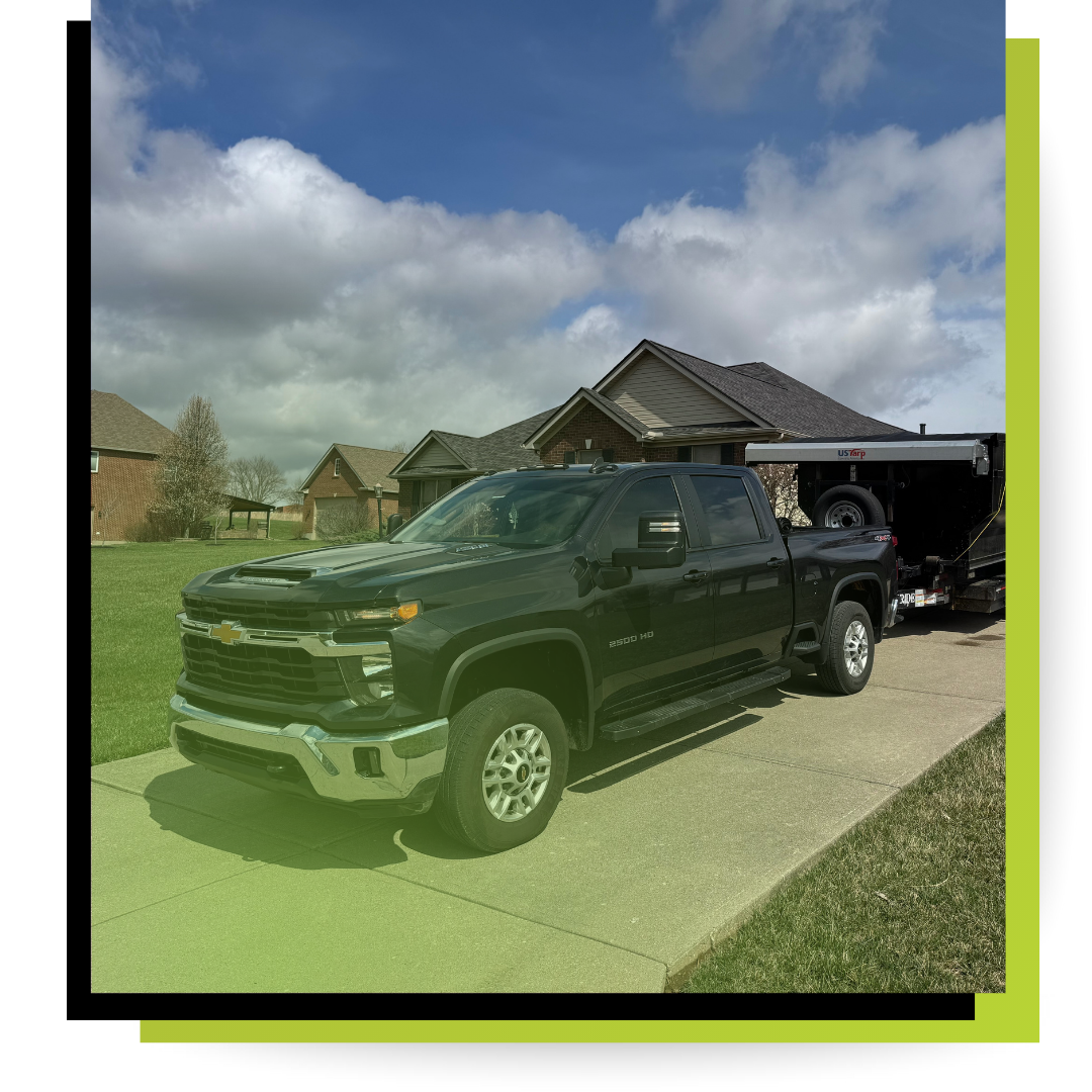 Tru-clean dumpster truck in fornt of a house