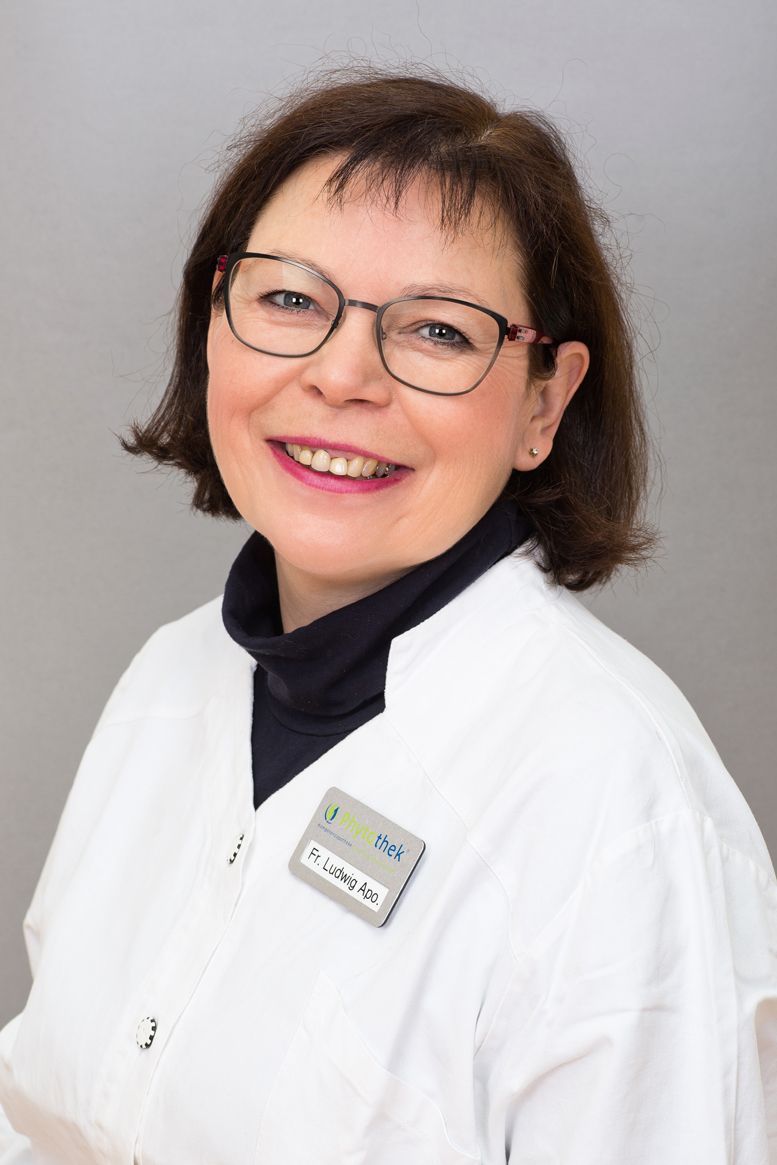 Eine Frau mit Brille und weißem Kittel lächelt in die Kamera.