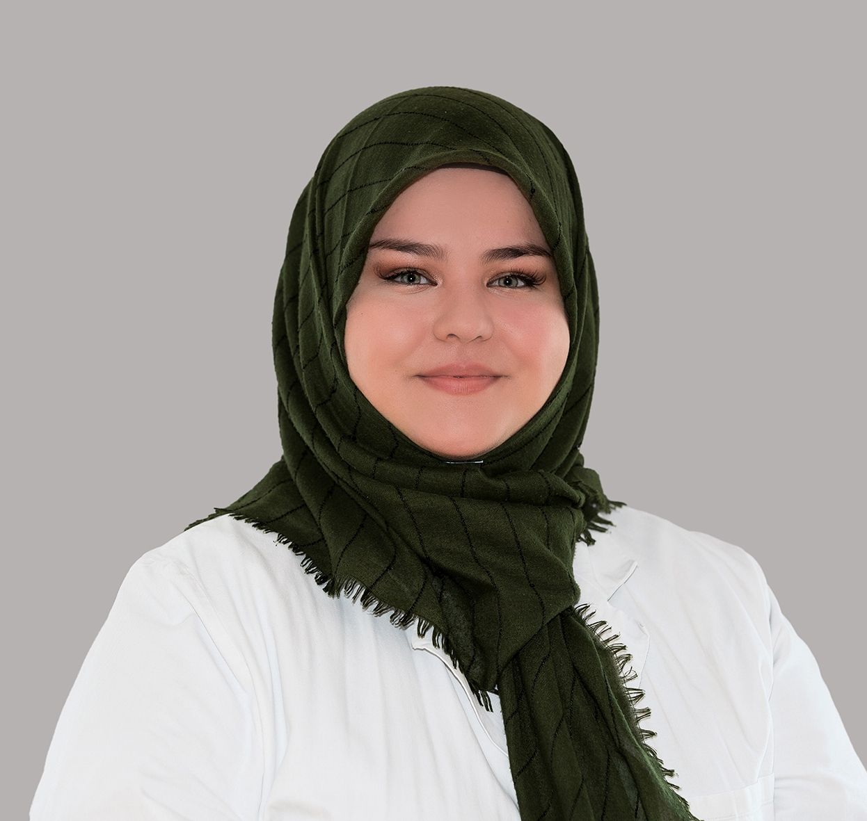 Eine Frau trägt ein weißes Hemd und einen grünen Schal.