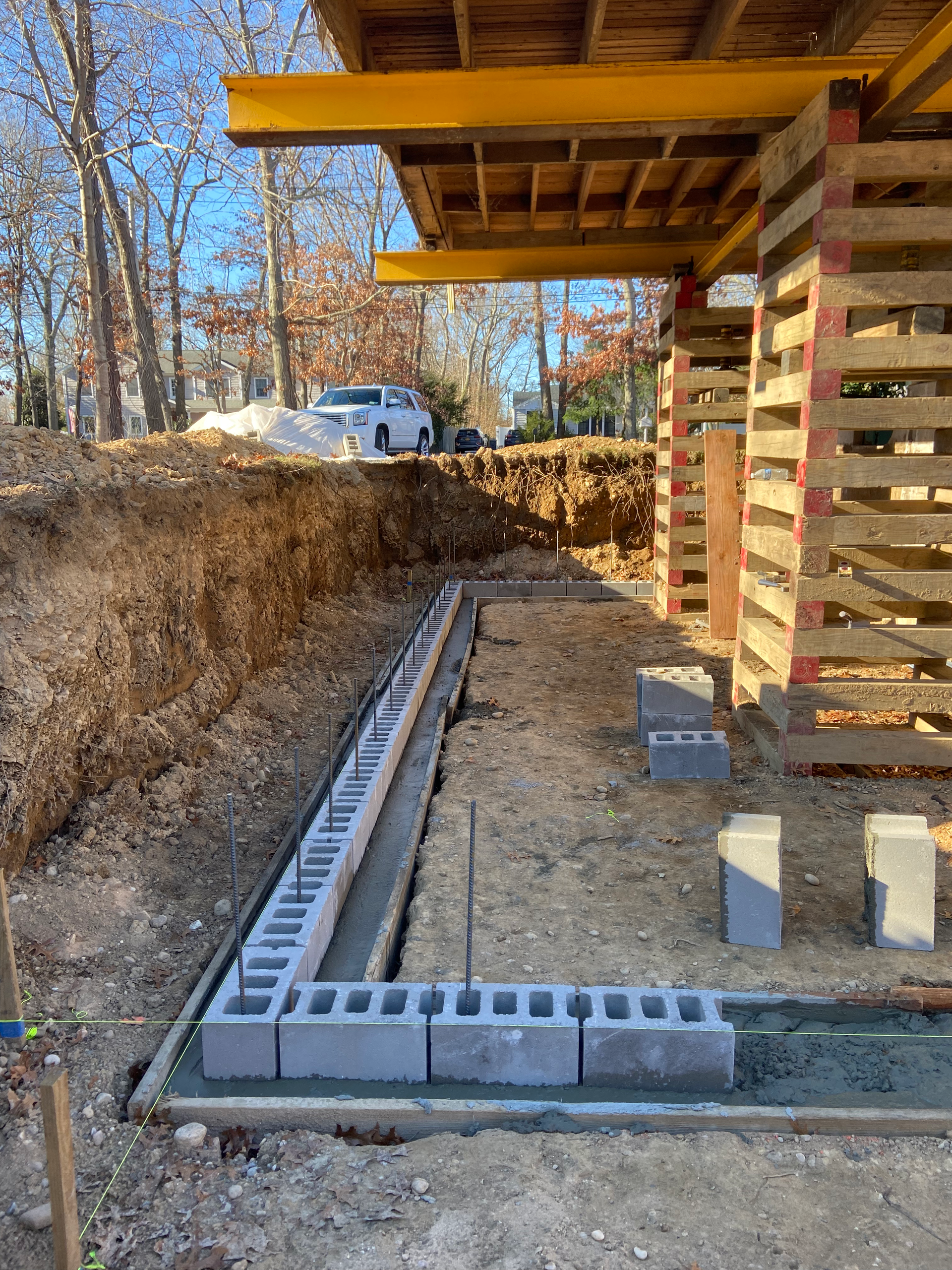 A concrete block wall is being built in a construction site.