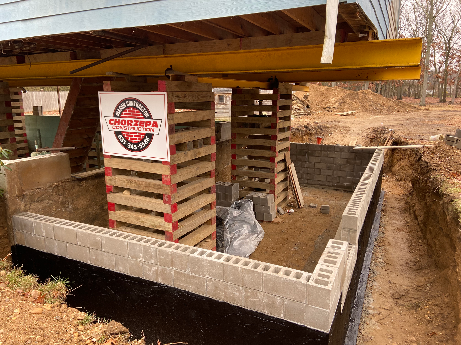 A house is being built with a sign on the side of it.