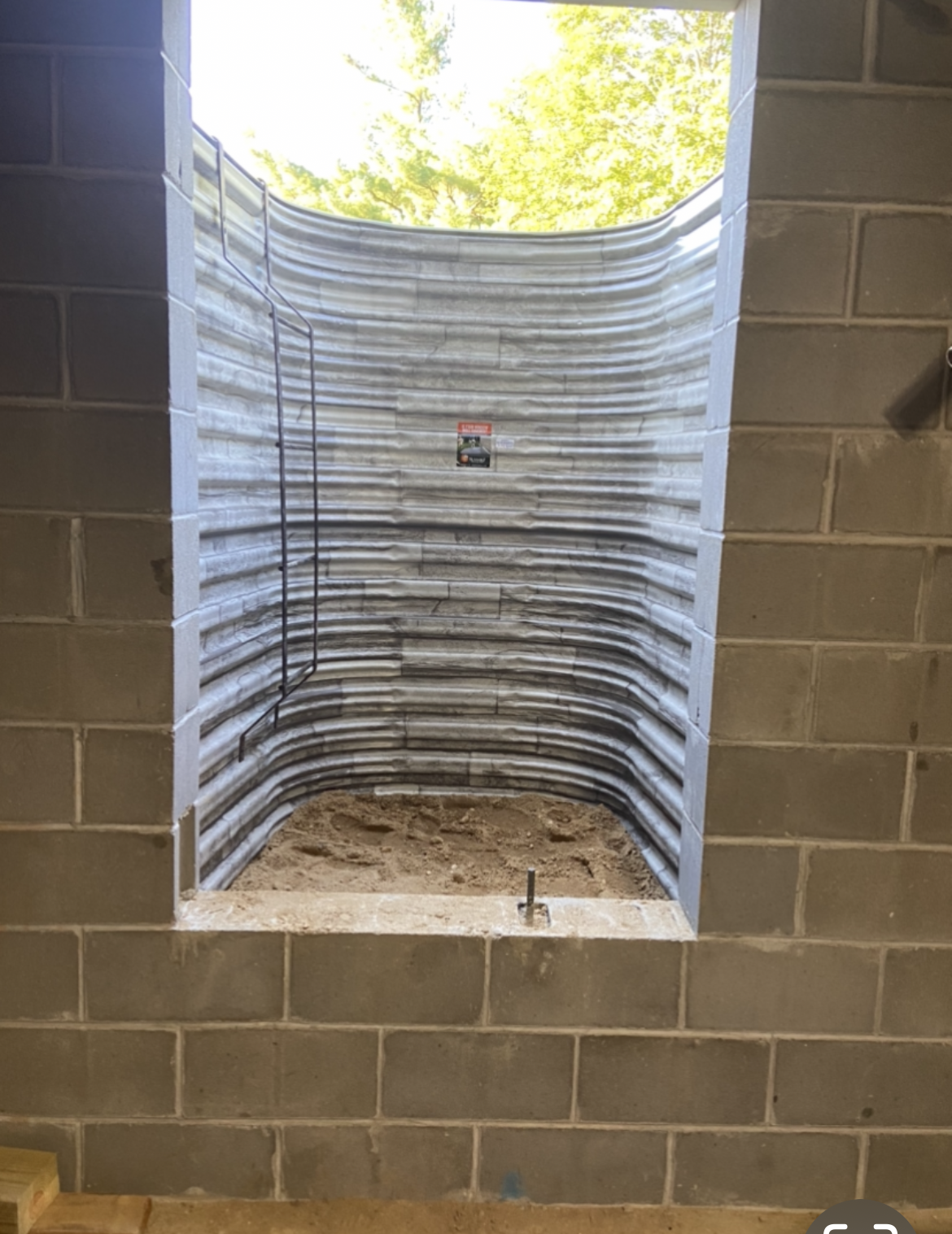 A brick wall with a window in the middle of it.