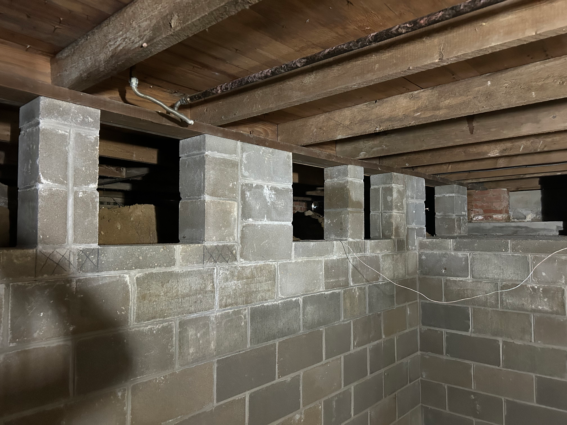 A basement with brick walls and wooden beams.