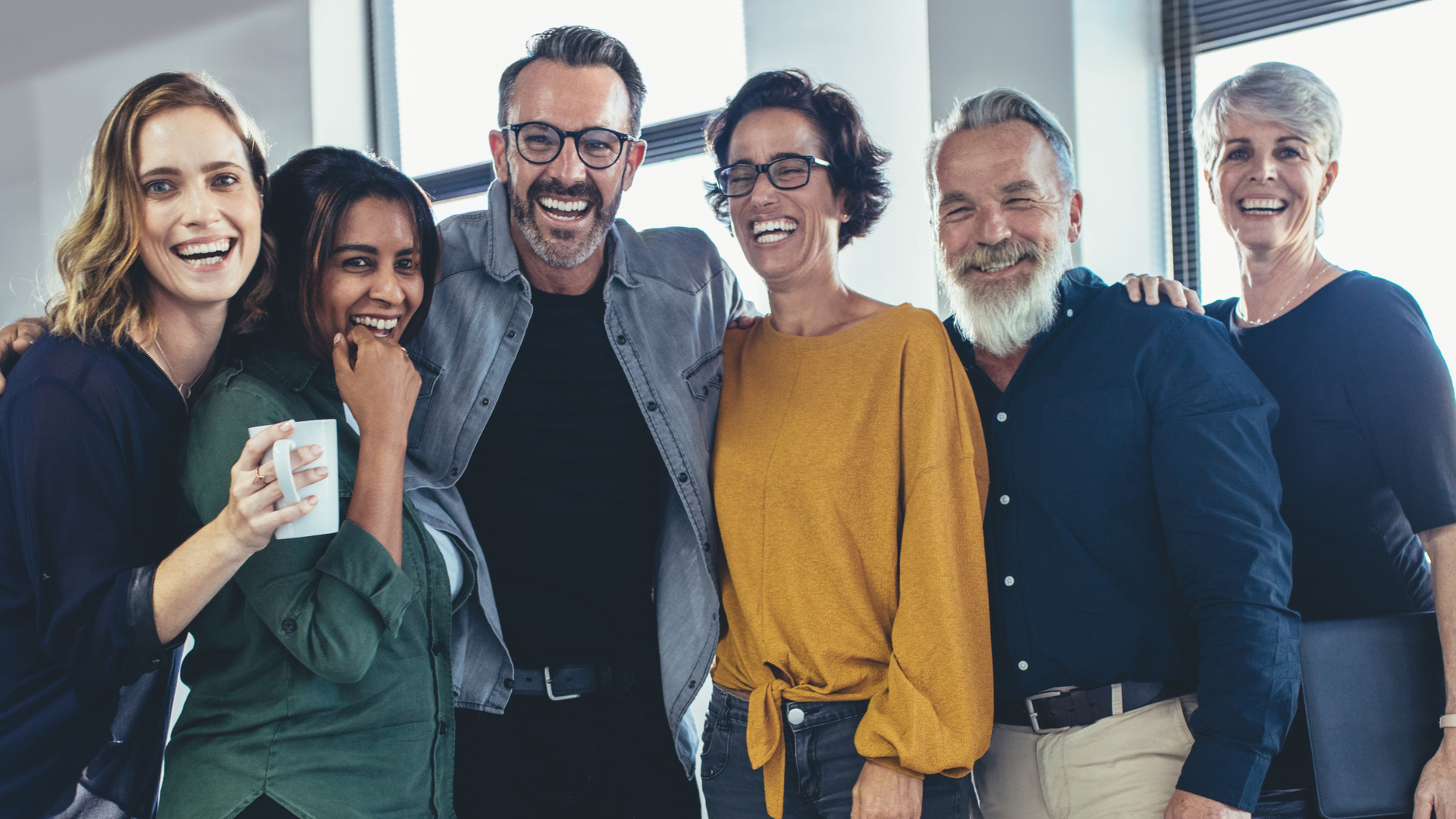 A group of people are posing for a picture together and smiling.