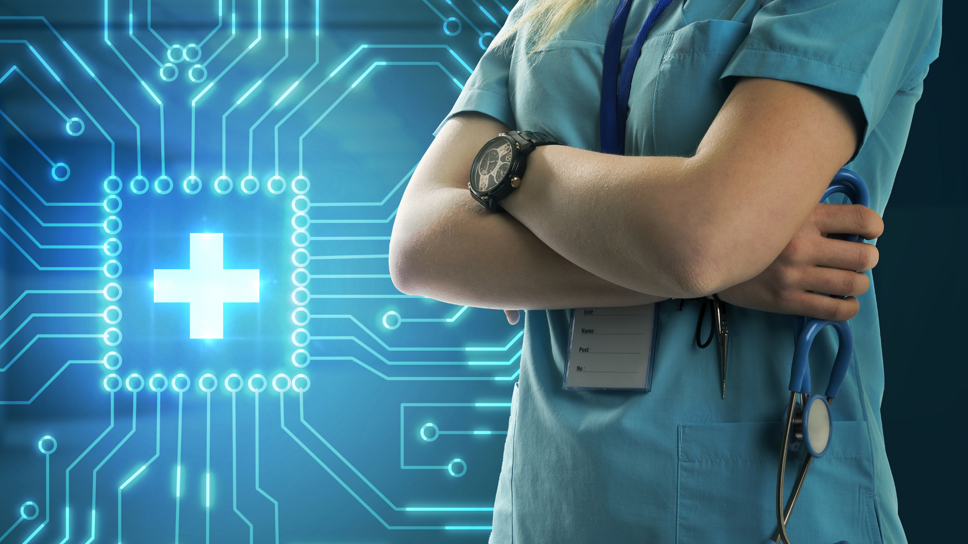A nurse is standing with her arms crossed in front of a computer chip.