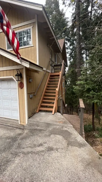 A house with stairs leading up to the second floor and a garage.