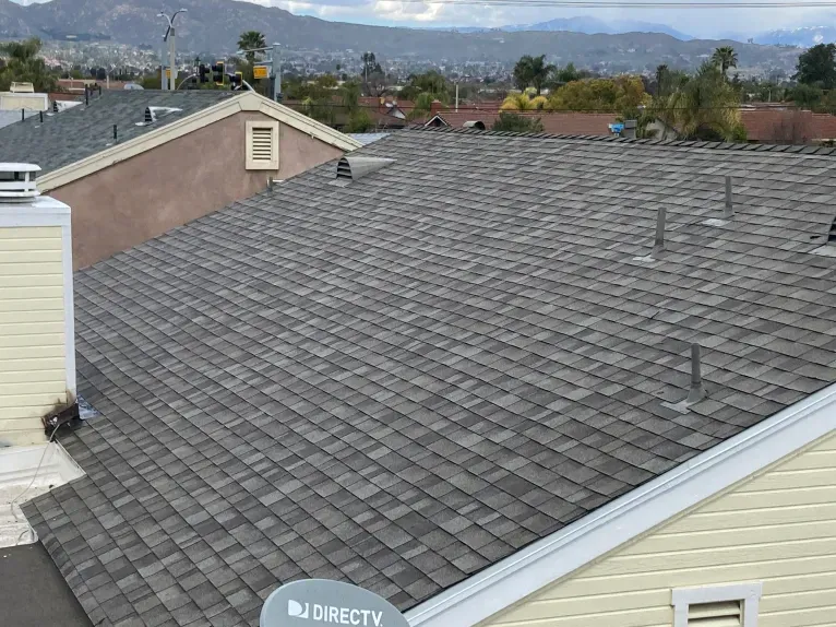 The roof of a house with a directv satellite dish on it.