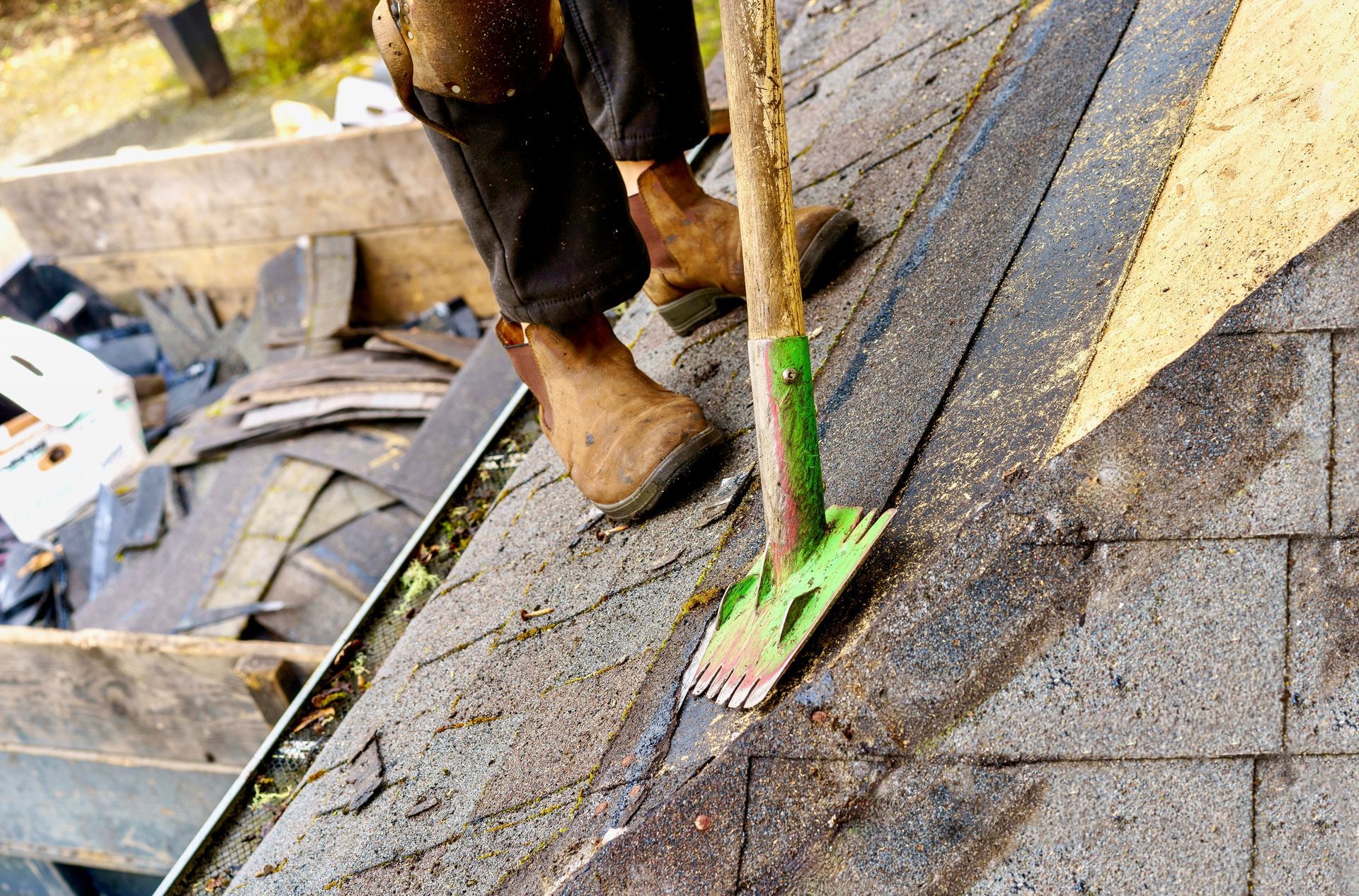 A person is cleaning a roof with a broom.