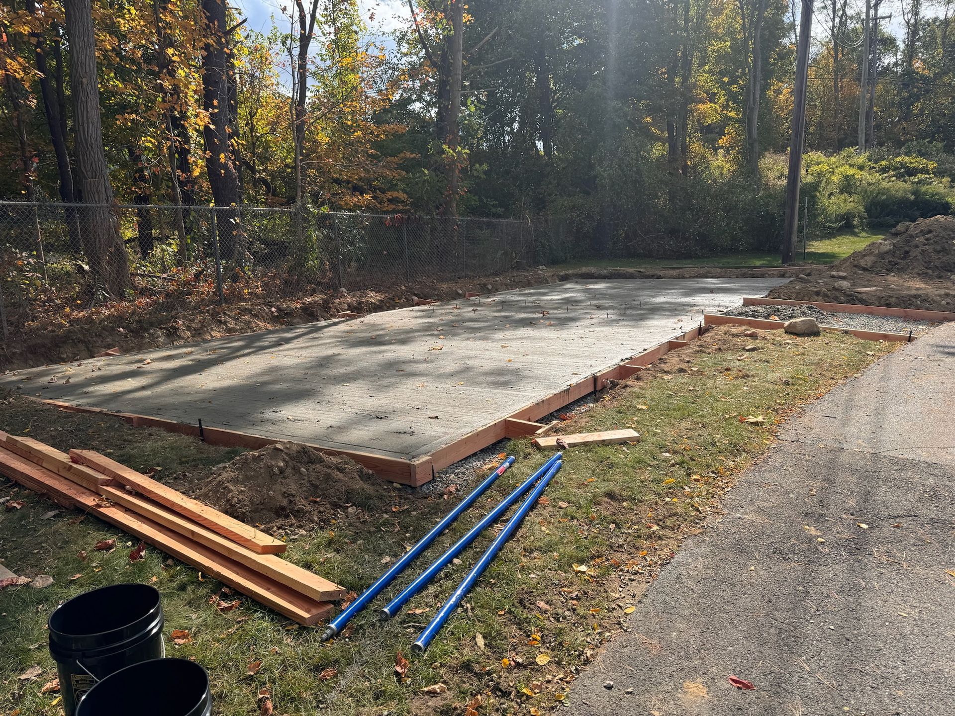 A concrete base for a garage is being built in the woods.