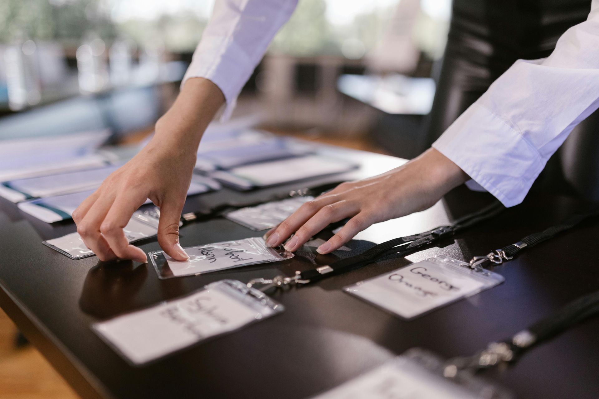 A woman is putting name tags on a table.