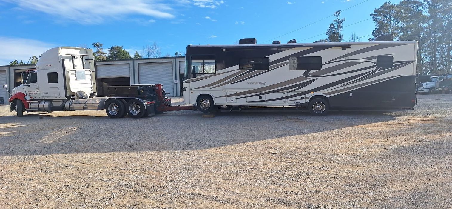 A rv is being towed by a semi truck