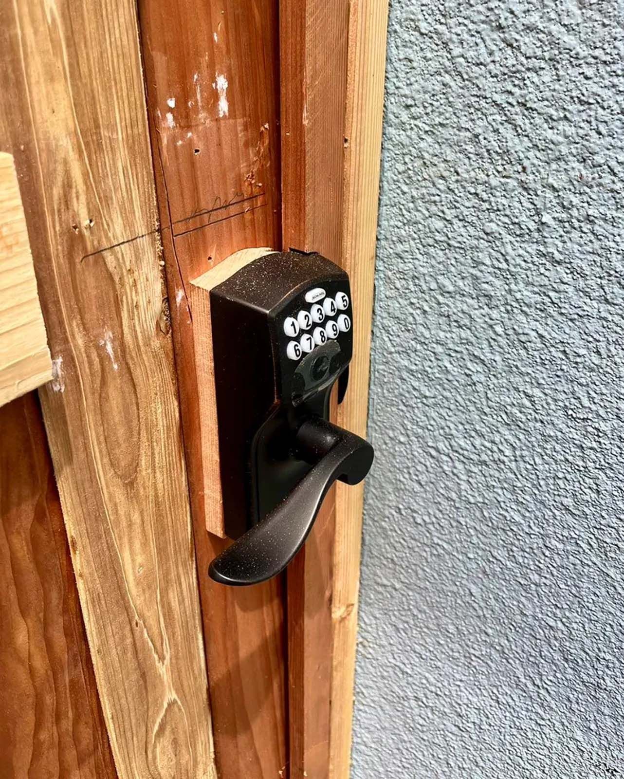 A close up of a door lock on a wooden door.