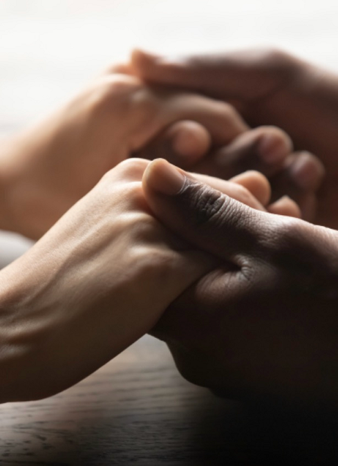 A man and a woman are holding hands on a table.