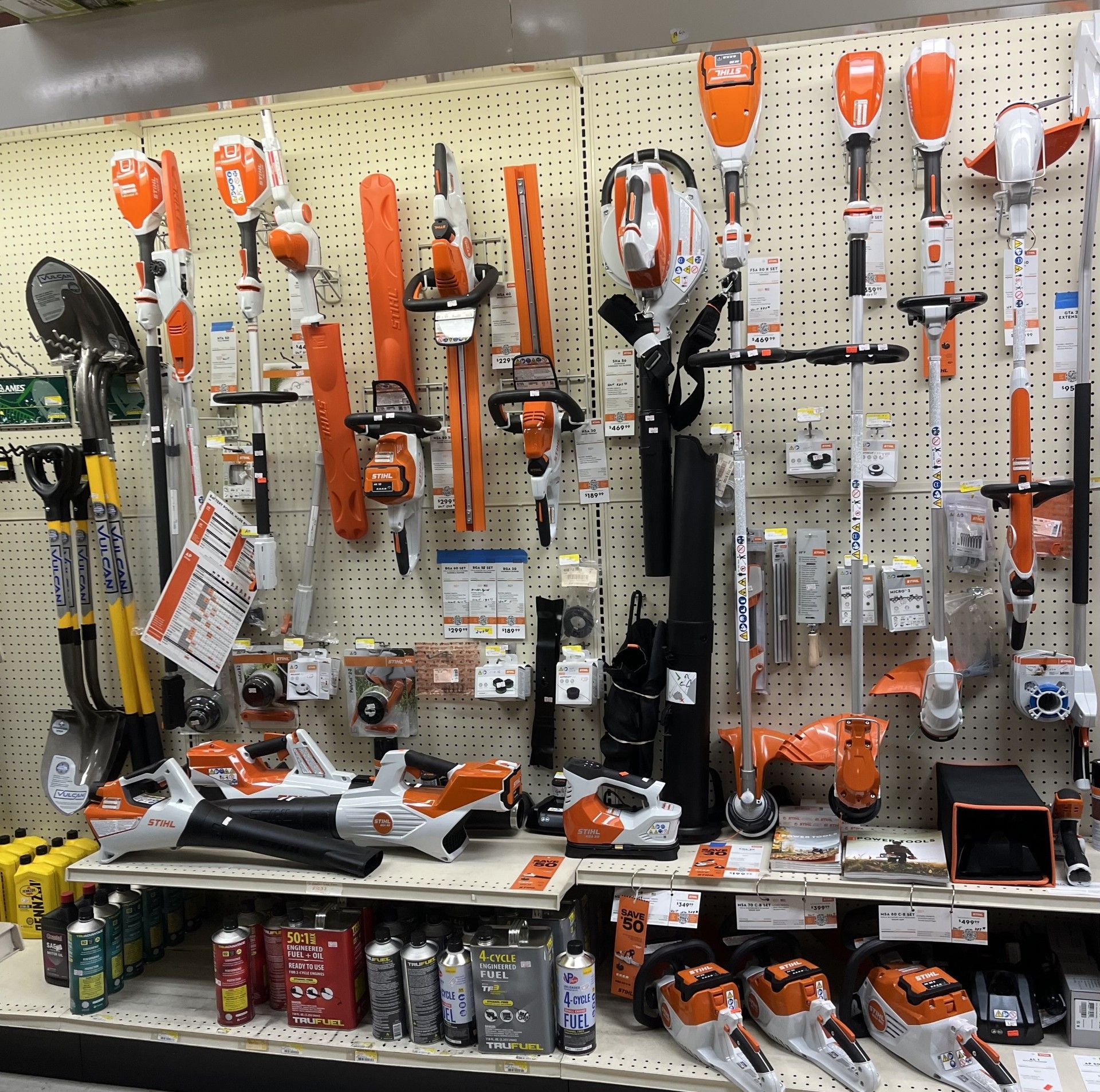 Red and black chainsaw resting on a wooden surface outdoors, blurred background.