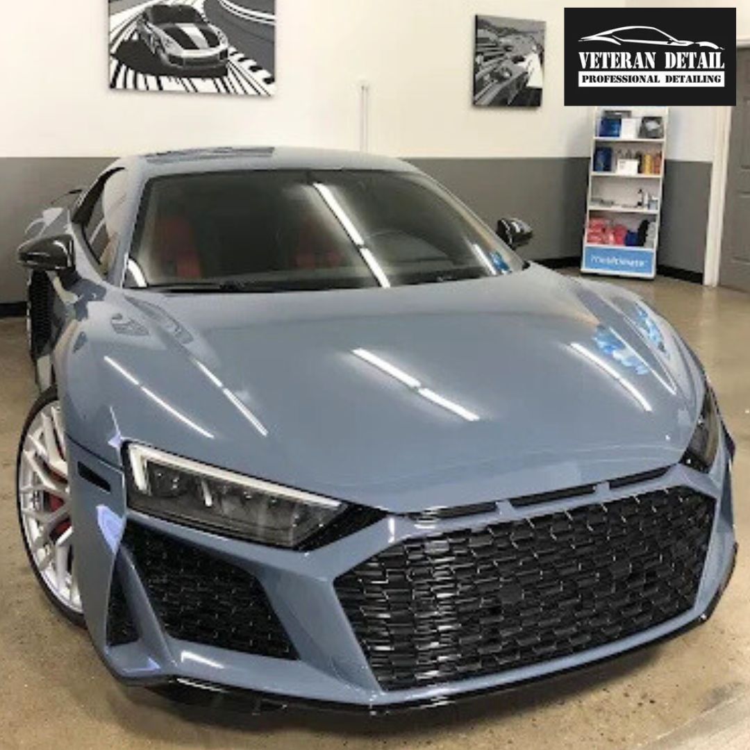 A gray Audi R8 sports car in a detailing shop.