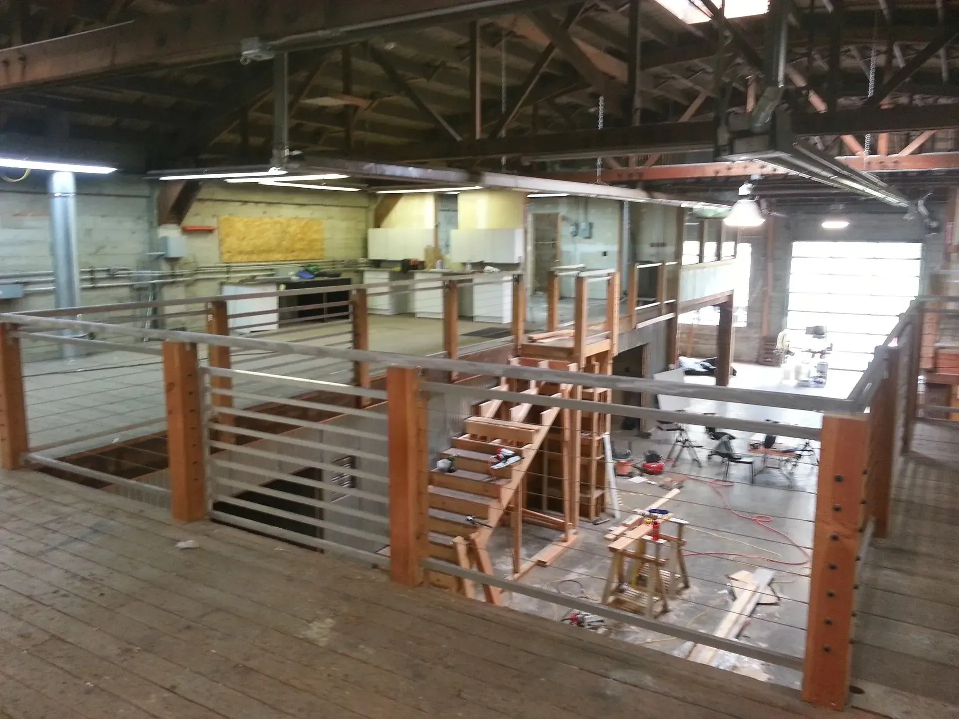 Wooden and metal structure under construction inside a large, open-air building.