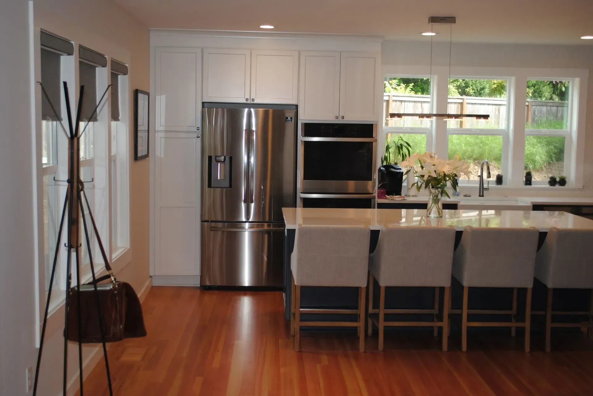 Modern kitchen with white cabinets, stainless steel appliances, and a large island with seating.