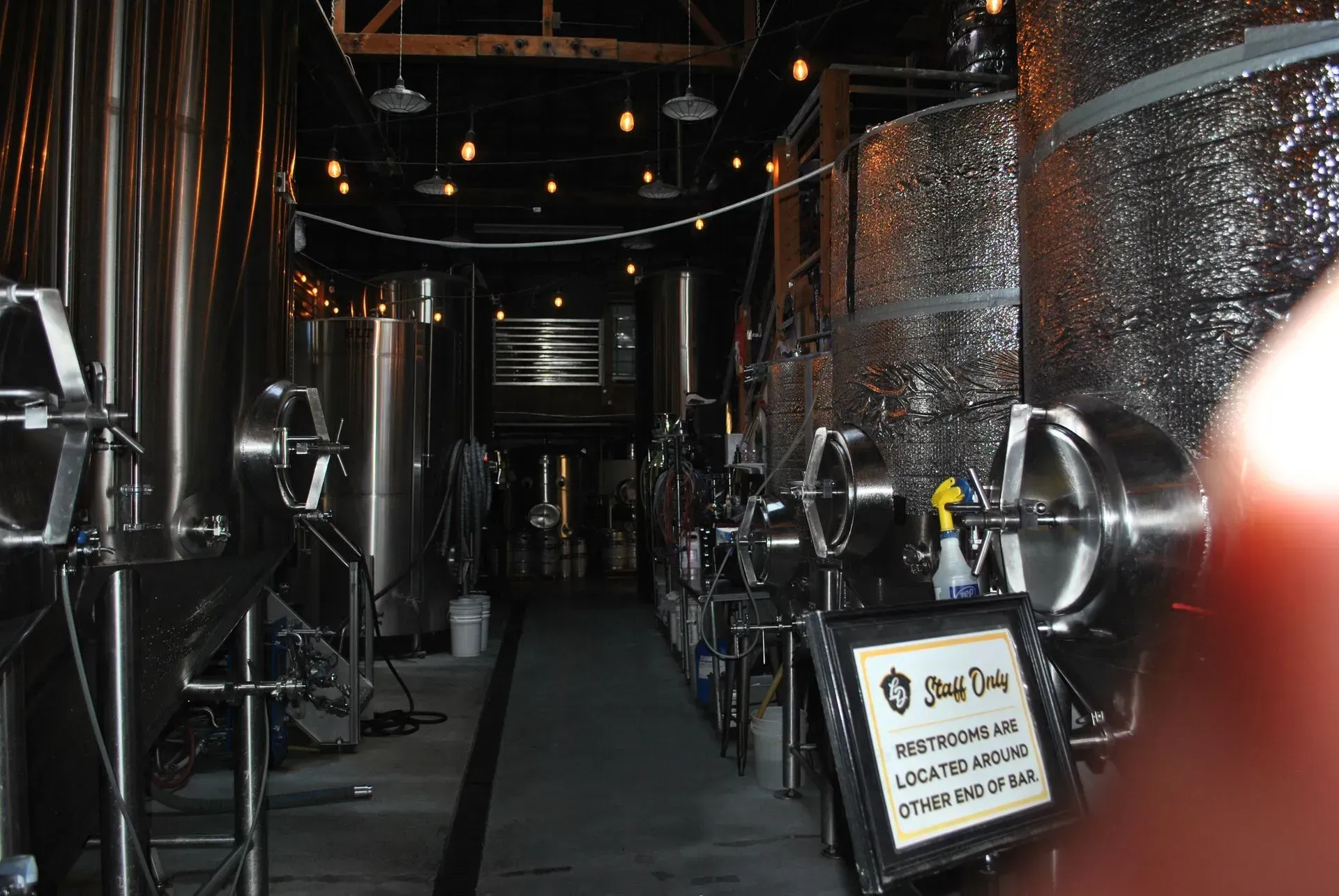 Tanks inside brewery. Large, stainless steel containers line the interior. 