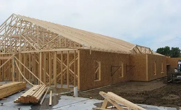 Construction of a wooden building with exposed framing and roof trusses.