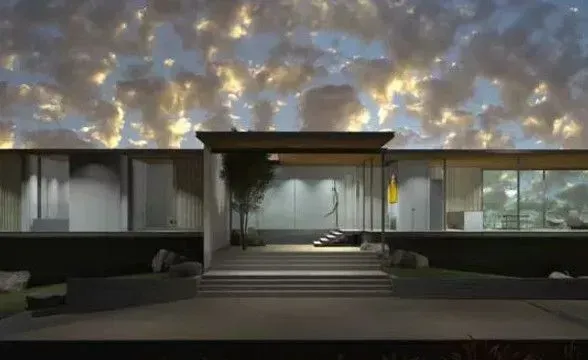 Modern home exterior with large glass windows and an open entry, under a cloudy sky.