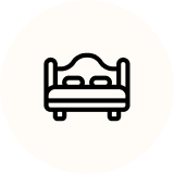 Bed icon, black outline, two pillows on mattress.