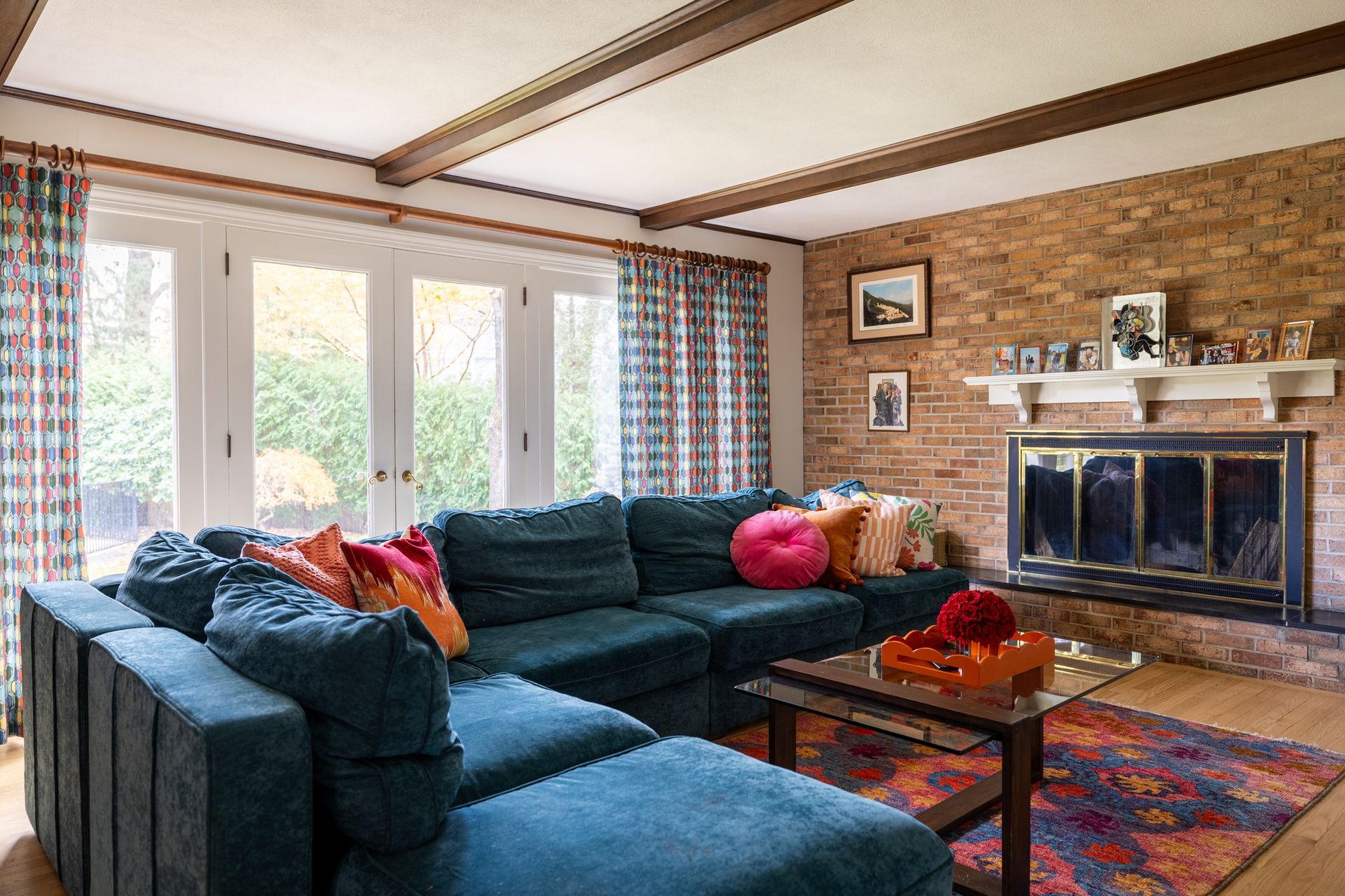 Elegant home office with a black leather chair and a gold-trimmed glass desk. Artwork hangs on a cream wall.