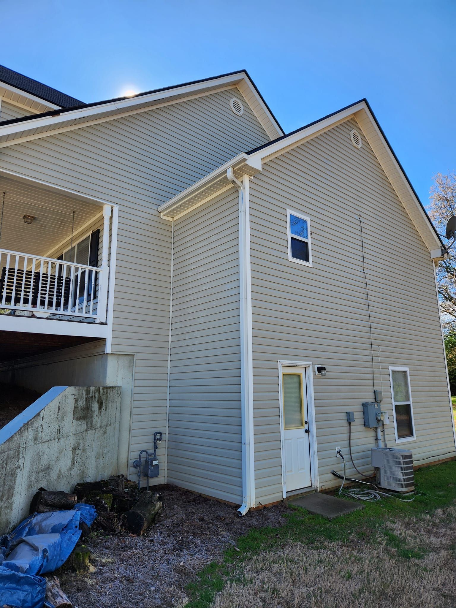 The back of a house with a balcony and a door.