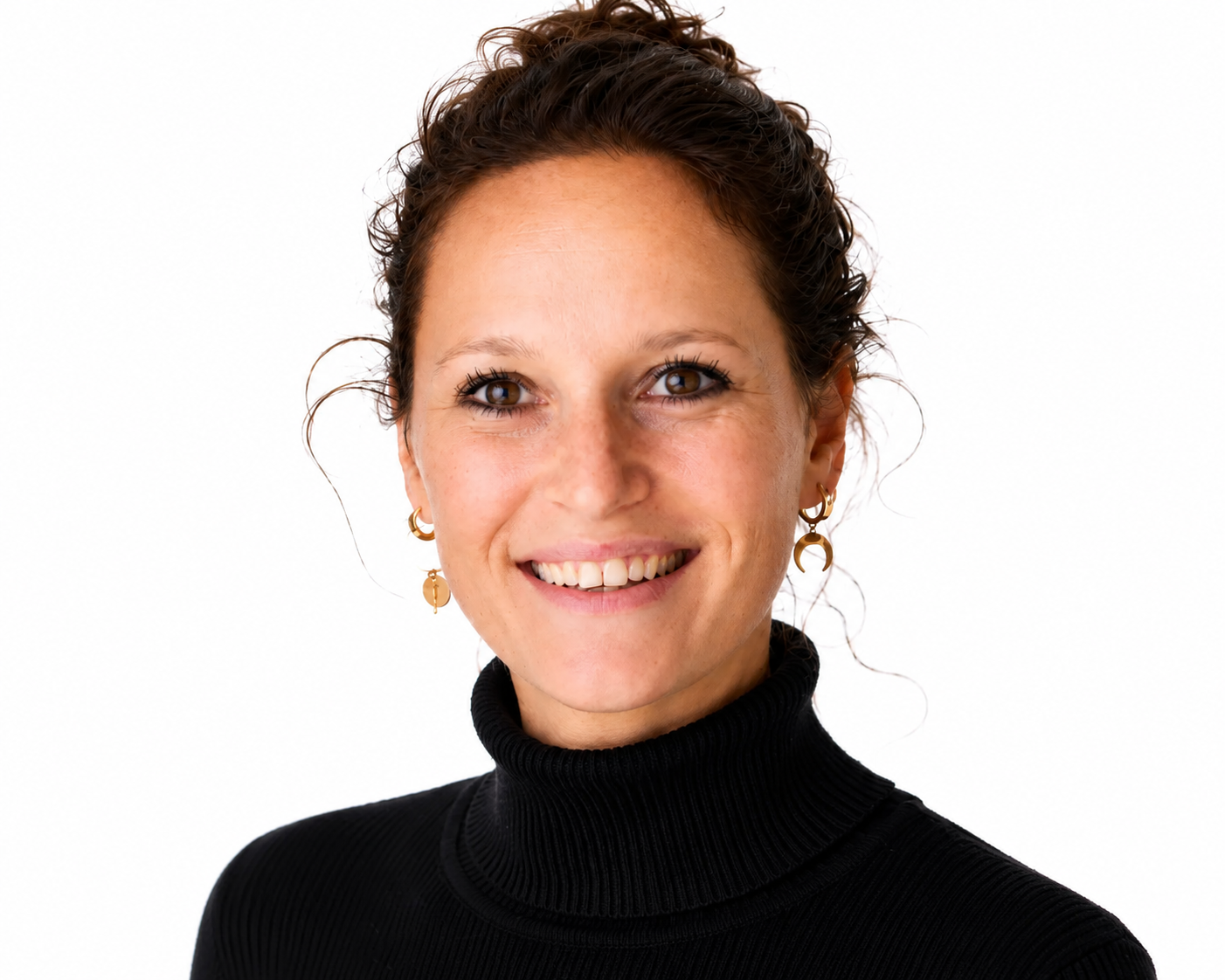 Lachende vrouw met krullend haar, gekleed in een zwarte coltrui, op een witte achtergrond.