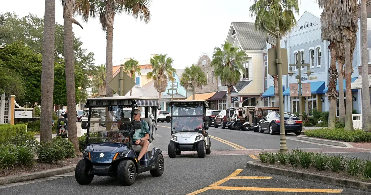 The Villages, FL traffic area with golf carts and tourists.