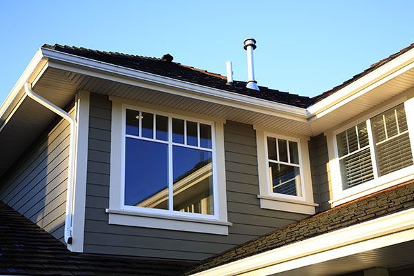 A house with a lot of windows and a chimney on the roof