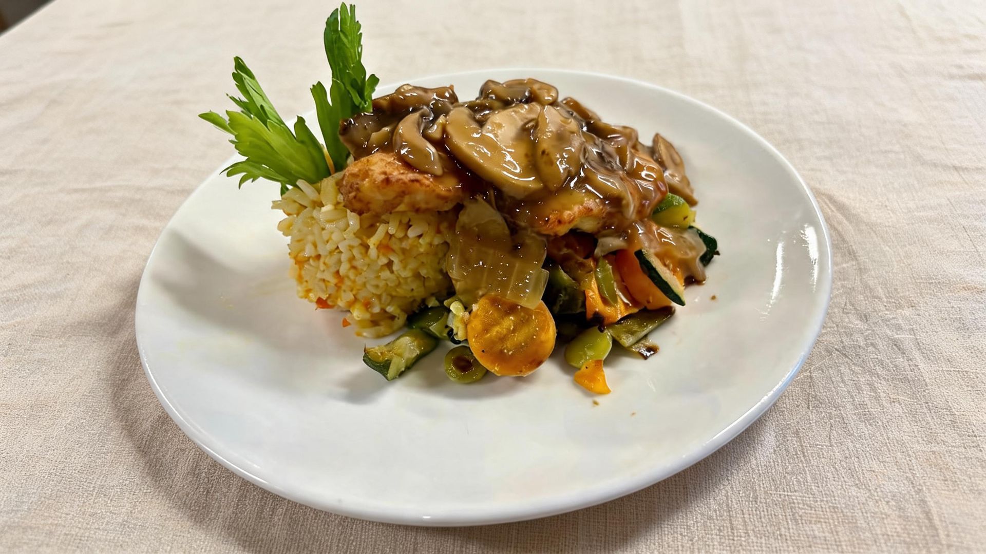 Plated entrée with grains, vegetables, and mushrooms on a white plate, garnished with parsley