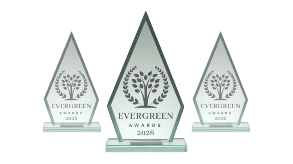 Three glass Evergreen Awards trophies, with tree design and 2026 and 2025 inscriptions, set against a white background.