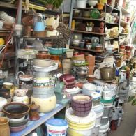 Shelves packed with a large variety of colorful ceramic pots, planters, and garden containers in a shop.