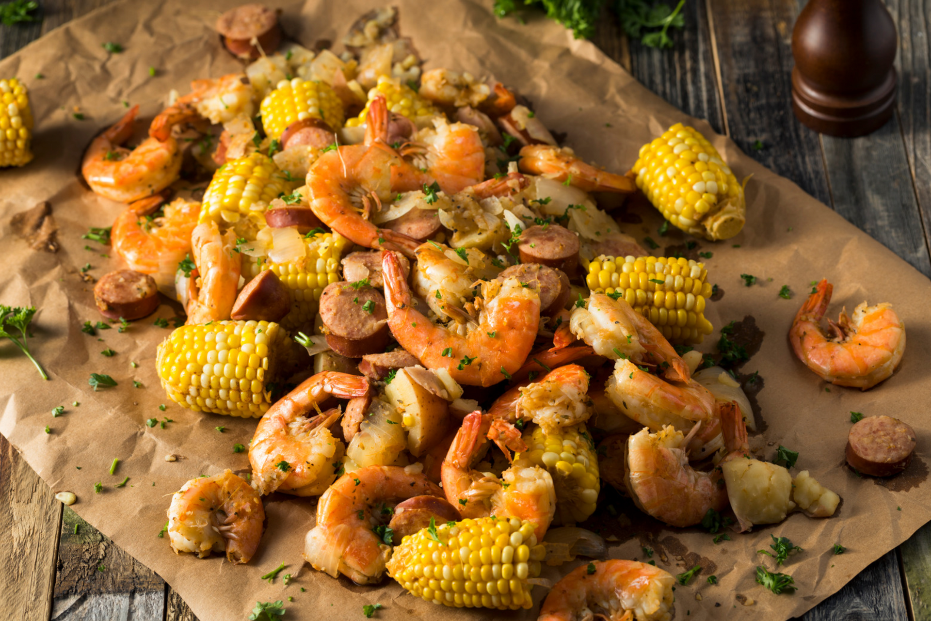 A full plate of Southern-style seafood boil with shrimp, corn-on-the-cob, and sausage.