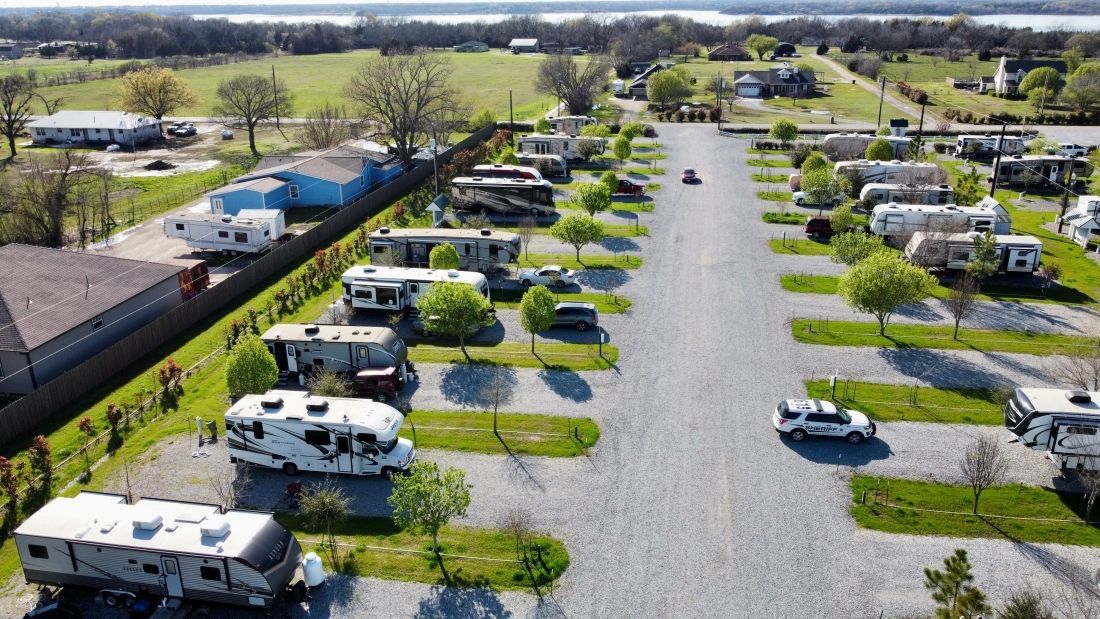 An aerial view of a rv park with a lot of rvs parked in the grass.