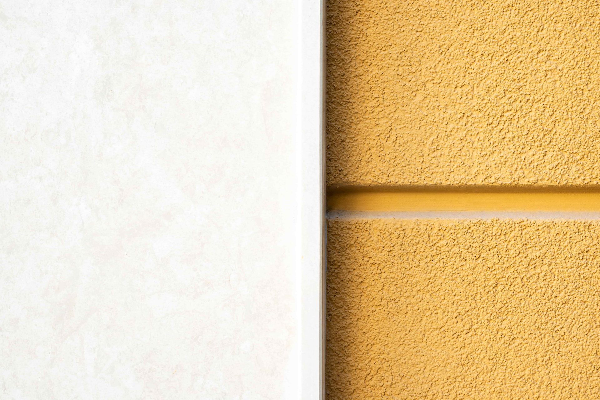 Off-white and mustard yellow textured walls divided by a narrow white strip and a horizontal yellow line.